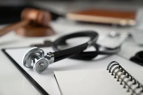 Gavel, notebook and stethoscope on the white table