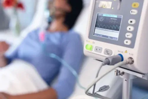 patient in hospital bed with oxygen ventilator