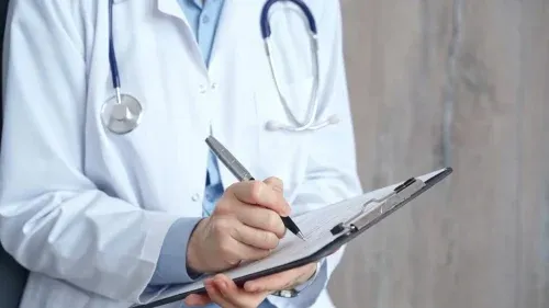Healthcare professional doctor writing medical records on a clipboard. Female unrecognizable physician at work. Medicine and pharmacy